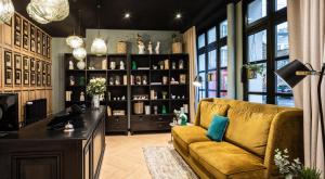 Una sala de estar con un sofá y una estantería. en Hôtel Lanjuinais, en Rennes