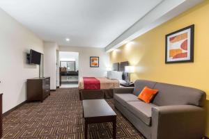 a hotel room with a couch and a bed at Scottish Inns & Suites Spring - Houston North in Spring