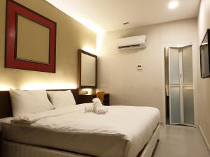 a bedroom with a bed with a towel on it at Ants Hotel in Kangar