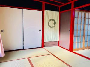 una stanza vuota con pareti rosse e porte in vetro di Yokohama Sakae-chou Ninja House #JA1 a Yokohama