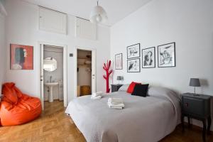 una camera da letto bianca con un letto e un pouf arancione di Bella Napoli Art Gallery a Napoli