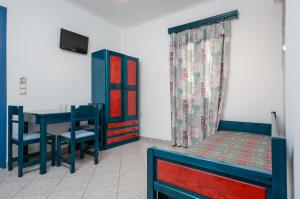 a bedroom with a bed and a table and chairs at Polemis Studios & Apartments in Agia Anna Naxos