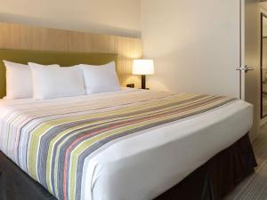 A bed or beds in a room at Country Inn & Suites by Radisson, Murrells Inlet, SC