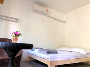 a bed sitting in a room next to a desk at Eco Capsule Resort at Teluk Bahang, Penang in Batu Ferringhi
