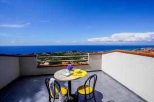 a table on a balcony with a view of the ocean at Hotel Orizzonte Blu in Tropea