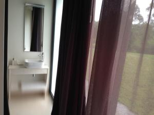 a bathroom with a sink and a mirror and a window at CAEaCLAVELES in La Pereda de Llanes