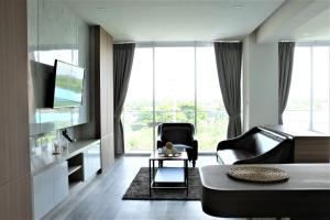 sala de estar con sofá y silla en Phurinda Residence, en Saraburi