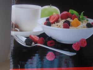 a bowl of cereal and fruit next to a cup of coffee at Bel Rea Guest Lodge in Nata