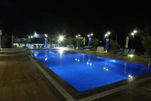 una piscina notturna con illuminazione blu di The Fern Residency Mundra a Mundra