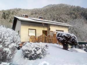 een huis met een hek in de sneeuw bij Ferienhaus Weiss in Lind bei Scheifling