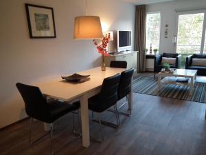 een woonkamer met een eettafel en stoelen bij Hollumerduinen in Hollum