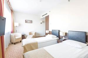 a hotel room with two beds and a television at Qubus Hotel Łódź in Łódź +42 photos