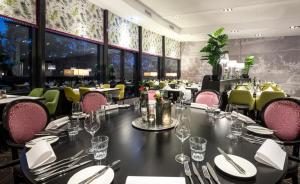 een eetkamer met een lange tafel en stoelen bij Van Der Valk Hotel Rotterdam Nieuwerkerk in Nieuwerkerk aan den IJssel