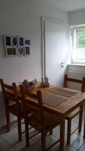 a wooden table and chairs in a dining room at Hof Heideland 2 - Fenster zum Hof in Eichholz