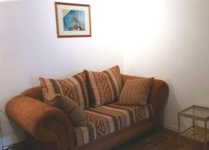 a brown couch in a room with a picture on the wall at Hof Heideland 2 - Fenster zum Hof in Eichholz