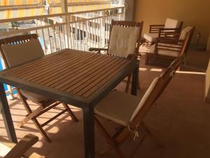 drewniany stół i krzesła na balkonie w obiekcie 2 dorm.A/A.Vista mar.WiFi.Gym.Sauna.Terraza.Parking. w mieście El Campello