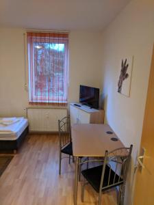 een kamer met een tafel en stoelen en een bed bij Hostel Schützenbrücke in Quedlinburg