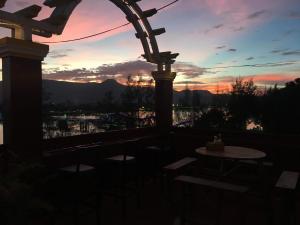 einen Sonnenuntergang von der Terrasse eines Hauses mit einem Tisch in der Unterkunft Good Morning Kampot in Kampot