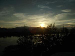 einen Sonnenuntergang über einem See mit der Sonne am Himmel in der Unterkunft Good Morning Kampot in Kampot