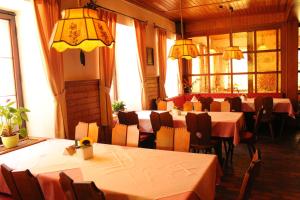 uma sala de jantar com mesas, cadeiras e janelas em Gasthof Rose em Hornberg