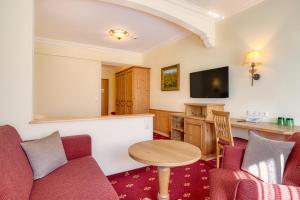 a living room with a couch and a table at Hotel Kristall in Grossarl