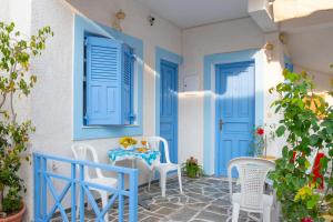 a room with blue doors and a table and chairs at Electra in Egina