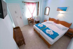 1 dormitorio con 1 cama con toallas en Electra, en Aegina Town