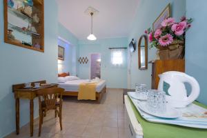 a hotel room with a bed and a dining room at Electra in Aegina Town