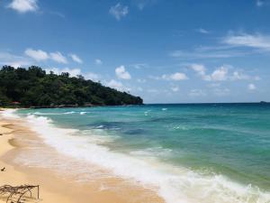 a beach with the ocean and trees in the background at Sleep Box Hostel Phú Quốc in Phu Quoc