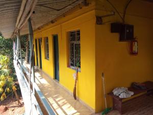 un bâtiment jaune avec une fenêtre sur son côté dans l'établissement Shiva Shanti Guest House, à Arambol