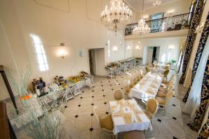 a banquet hall with tables and chairs and a chandelier at Hotel Sobienie Królewskie in Sobienie Szlacheckie +29 photos