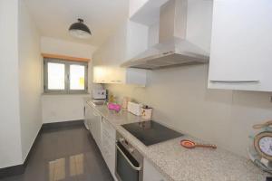 cocina con armarios blancos y encimera en DUPLEX, en Nazaré