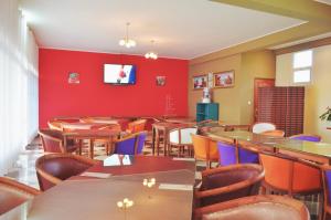 a restaurant with tables and chairs and a red wall at Anouk Hotel in Antananarivo