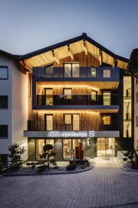 a building with a lit up sign in front of it at Alpinlounge Rätia Appartements in Ischgl