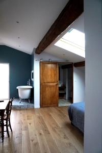 um quarto com uma cama e uma casa de banho com uma banheira em La Garoffe em Pibrac