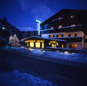 un hotel con un árbol de Navidad frente a un edificio en Hotel Mignon en Ponte di Legno