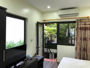 a bedroom with a flat screen tv and a large window at Ventana house in Hai Phong