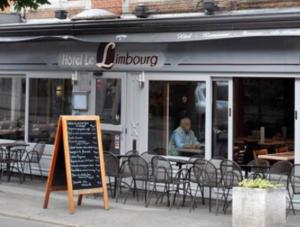 a restaurant with tables and chairs and a sign in front of it at Hotel Le Limbourg in Rochefort