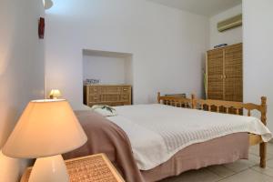 ein Schlafzimmer mit einem Bett und einer Lampe in der Unterkunft Li Cantori in Marina di Pescoluse