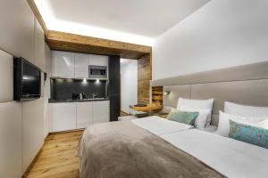 a hotel room with a large bed and a kitchen at Alpinlounge Rätia Appartements in Ischgl