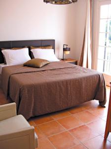 - une chambre avec un grand lit et une couverture brune dans l'établissement Lagrange Vacances Carré Beauchêne, à Sainte-Maxime