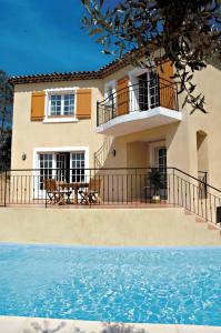 une maison avec un balcon et une piscine dans l'établissement Lagrange Vacances Carré Beauchêne, à Sainte-Maxime