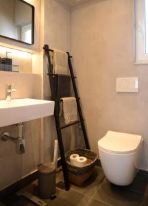 a bathroom with a white toilet and a sink at Boutique Apartment in Chalandri in Athens