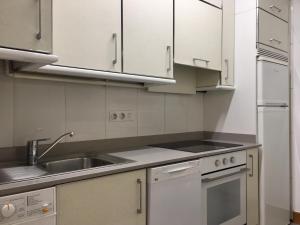 a kitchen with white cabinets and a sink at Plaza in San Sebastián