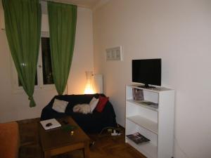 a living room with a couch and a television at By Lycabettus in the city-heart close to Acropolis in Athens