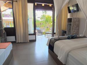 a bedroom with a bed and a view of a patio at Gili Air Bungalows in Gili Islands