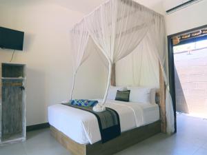 a bedroom with a bed with a canopy at Gili Air Bungalows in Gili Islands