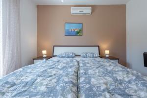 een slaapkamer met een bed met 2 kussens erop bij Villa Adria in Cavtat