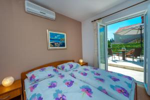 een slaapkamer met een bed en een glazen schuifdeur bij Villa Adria in Cavtat