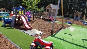 a playground with a toy car on the grass at Crea-Trends Vacations in Sluis